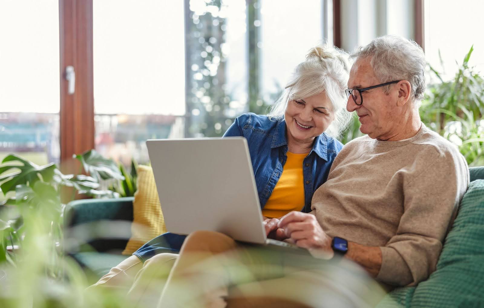 Senior couple researching senior living costs on a laptop computer