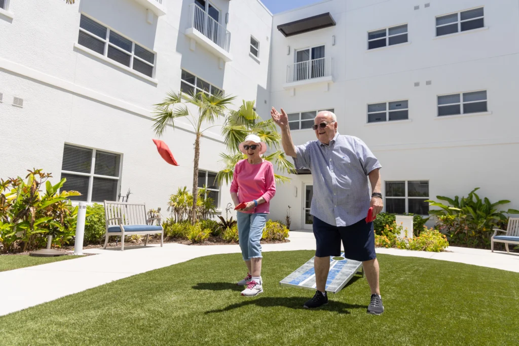 A senior couple playing Cornhole outside of Amavida, a retirment community in Fort Myers, FL.