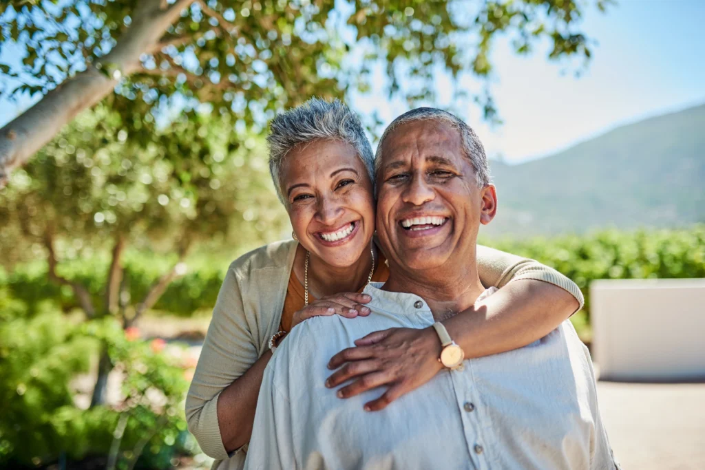 An elderly couple, residents of Amavida in Fort Myers, FL smiling about their one-bedroom apartment living situation.