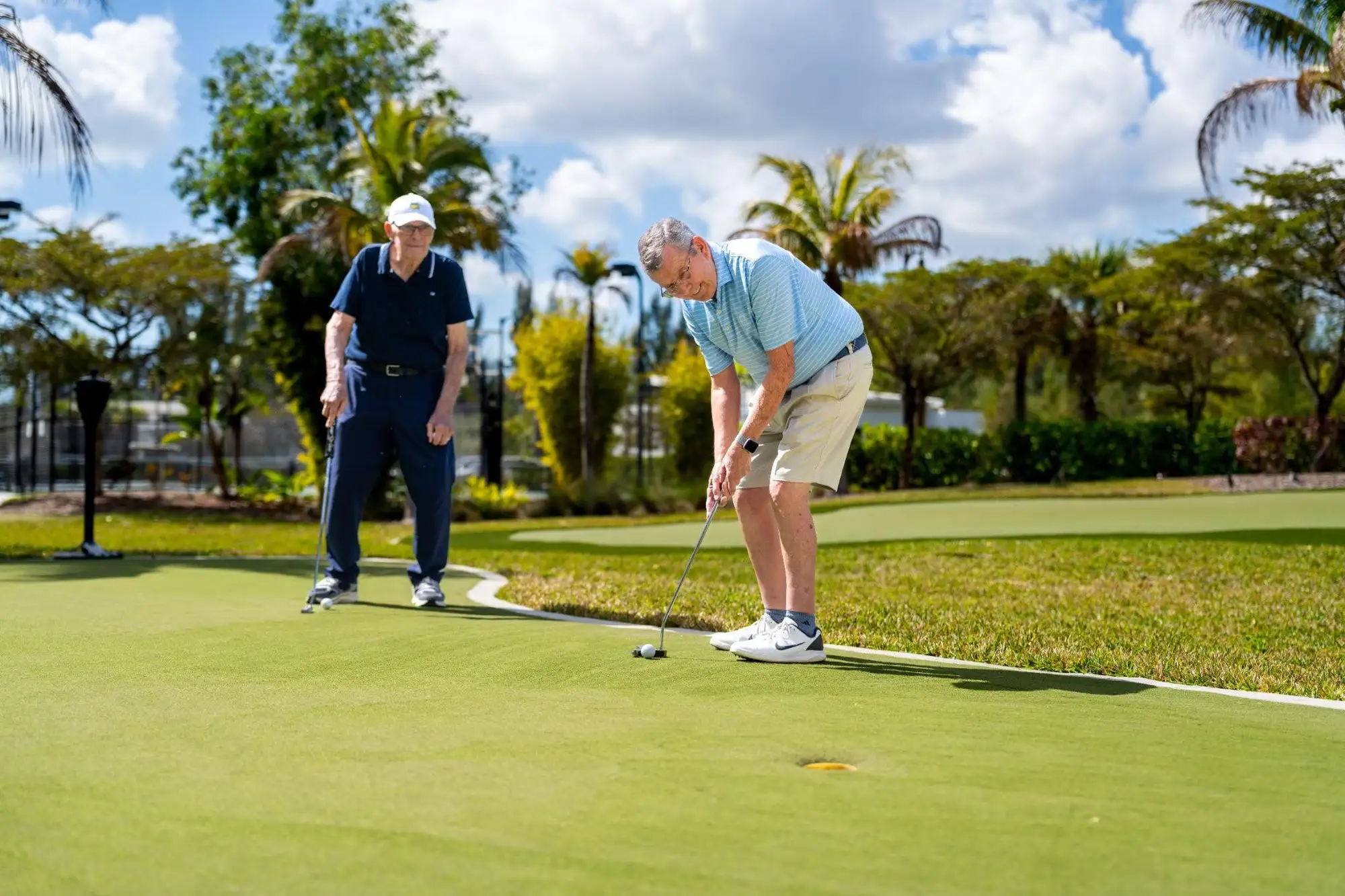 2 elderly men playing gold and enjoying a new kind of retirement lifestyle called active senior living in Florida at Amavida in Fort Myers. 